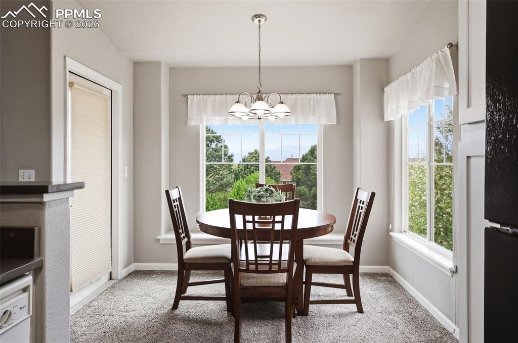 Image 8 of 32: Dining area with large windows and window treatments
