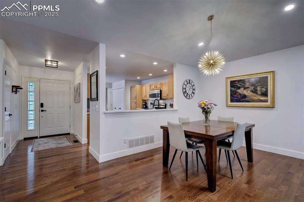 Image 16 of 40: Dining area with recessed lighting, dark wood-type flooring, and a chandeli