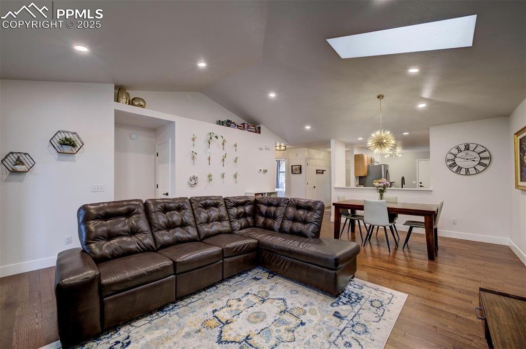 Image 20 of 40: Living area with a skylight, lofted ceiling, recessed lighting, wood finish