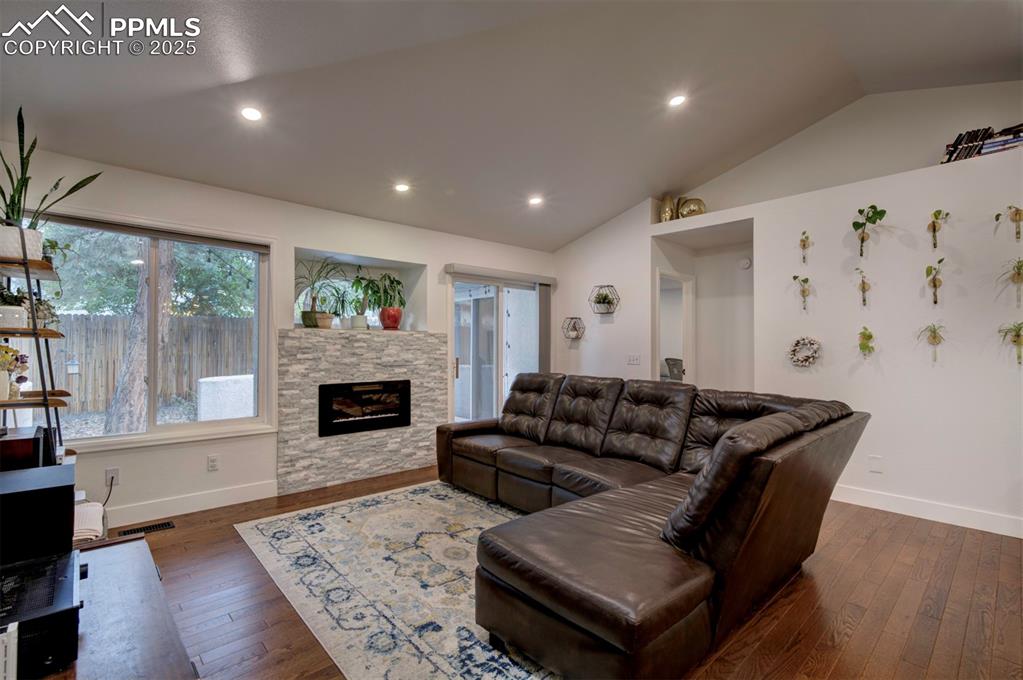 Image 21 of 40: Living room with vaulted ceiling, dark wood finished floors, recessed light