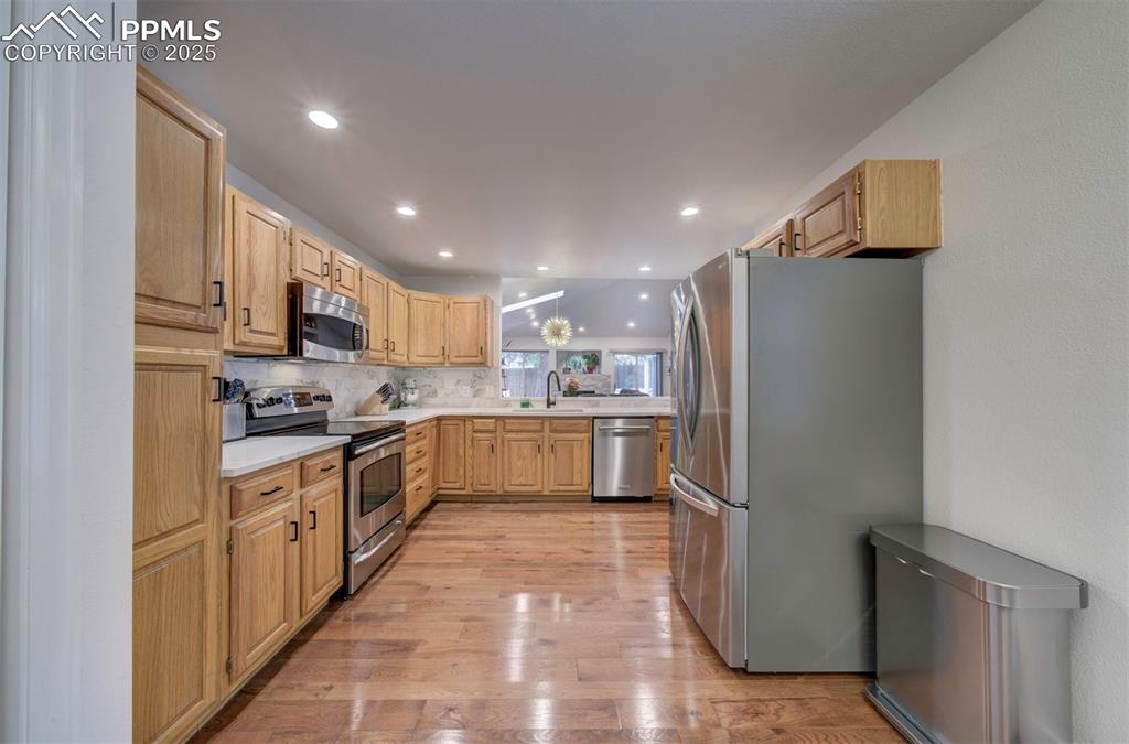 Image 25 of 40: Kitchen with appliances with stainless steel finishes, light wood finished