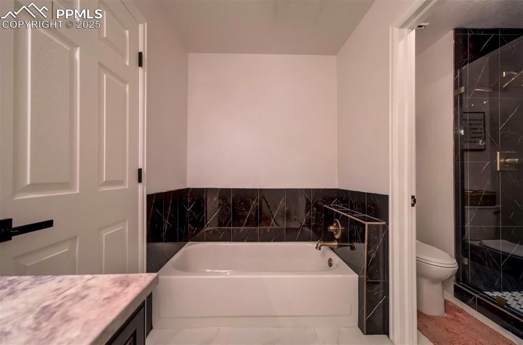 Image 32 of 40: Full bath with a bath, a stall shower, vanity, and tile patterned flooring