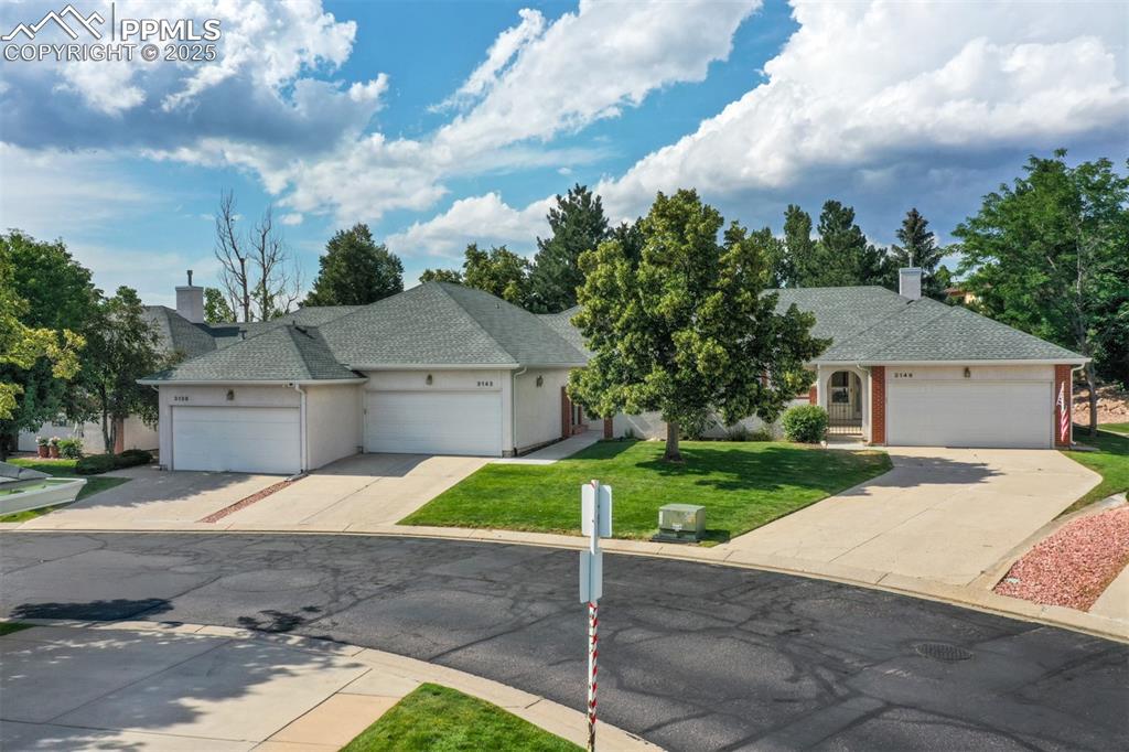 Image 7 of 40: View of front facade featuring a garage, a shingled roof, driveway, stucco