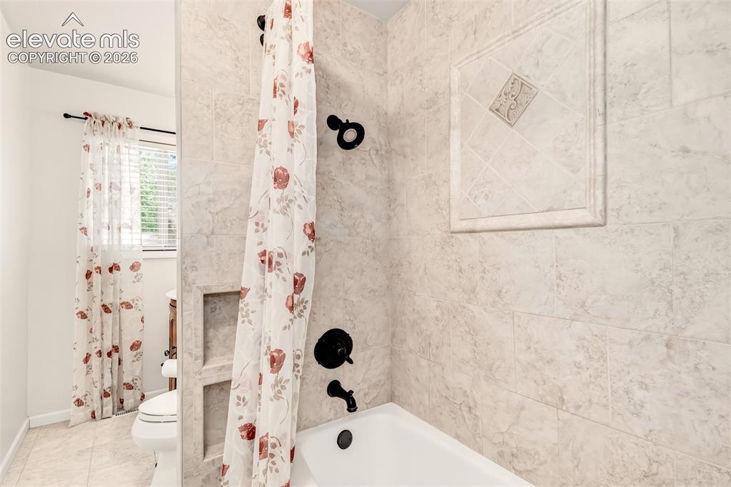 Image 13 of 30: Updated Guest Bathroom With Custom Tile And Built-Ins