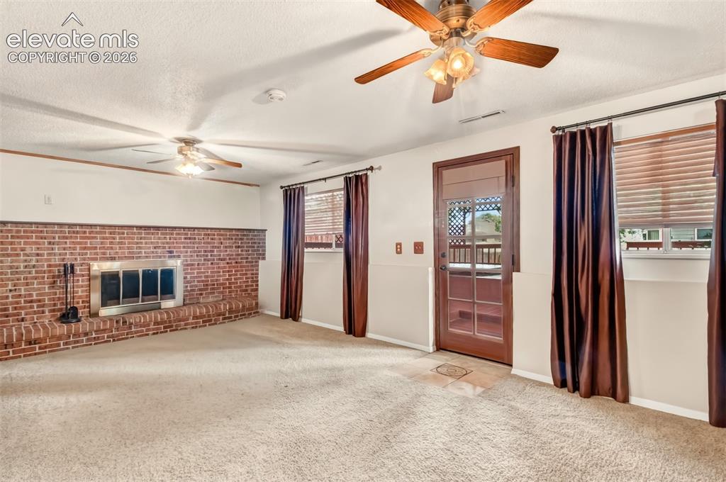 Image 18 of 30: Inviting Wood Fireplace With Brick Surround, Walk-Out To The Covered Back D