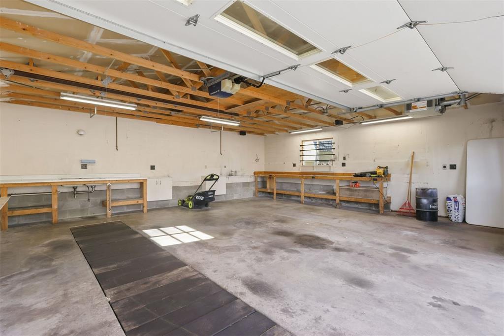 Image 26 of 45: The heated garage features a vehicle inspection pit.