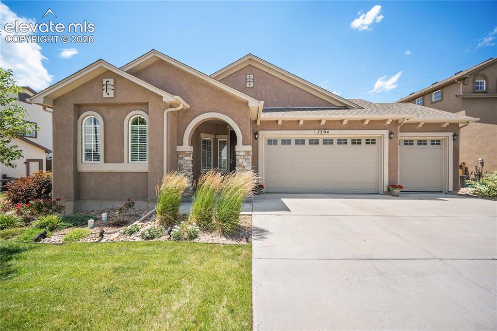 Image 1 of 49: Stucco and stone exterior, 3 car garage and covered front porch.