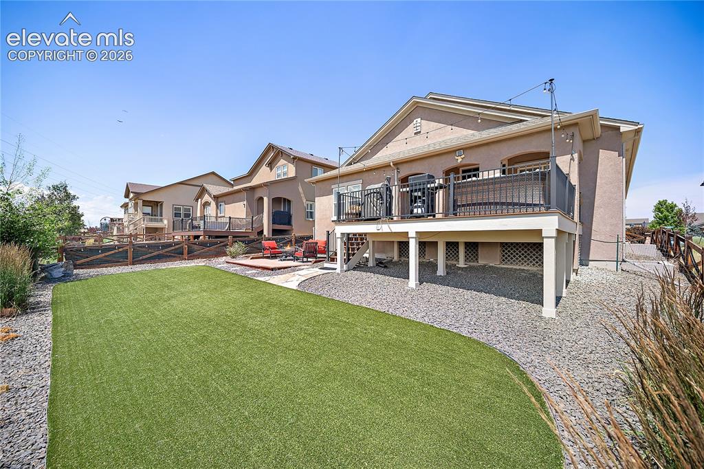 Image 35 of 49: View of the back of the home. Easy to maintain turf and mature landscaping.