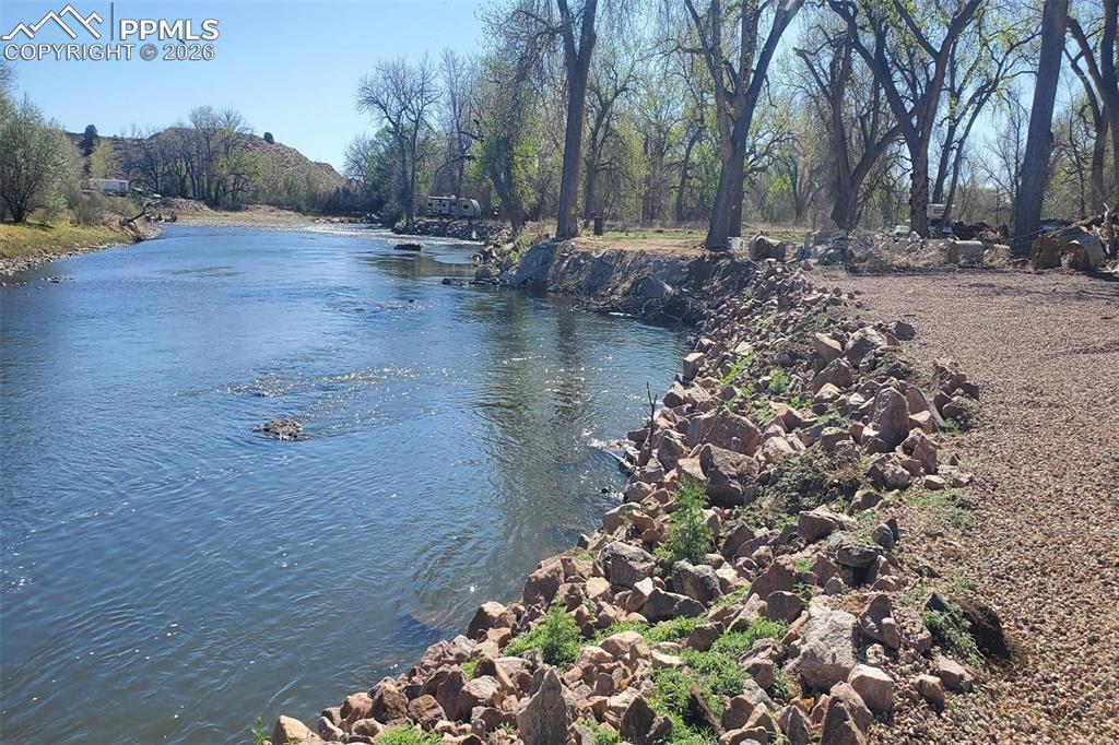 Image 4 of 27: This is the view east taken at the river, featuring a rock barrier to prote