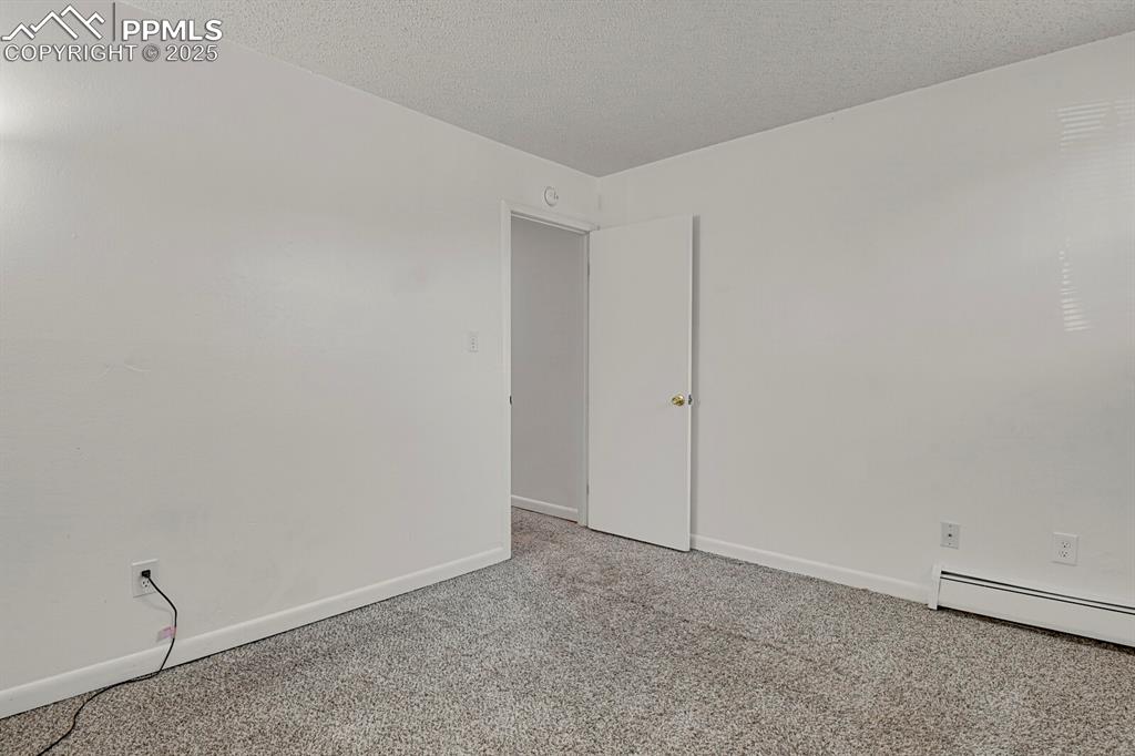 Image 14 of 17: Carpeted spare room featuring baseboards and a textured ceiling