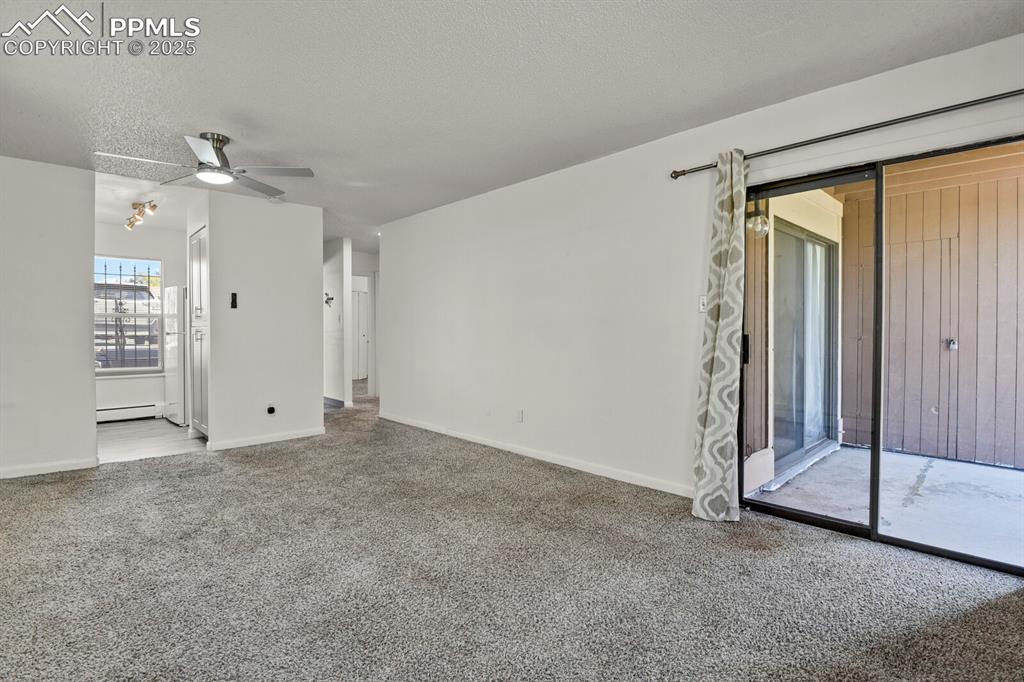 Image 3 of 17: Living room. Baseboard heating, A/C wall unit, Ceiling fan with remote.