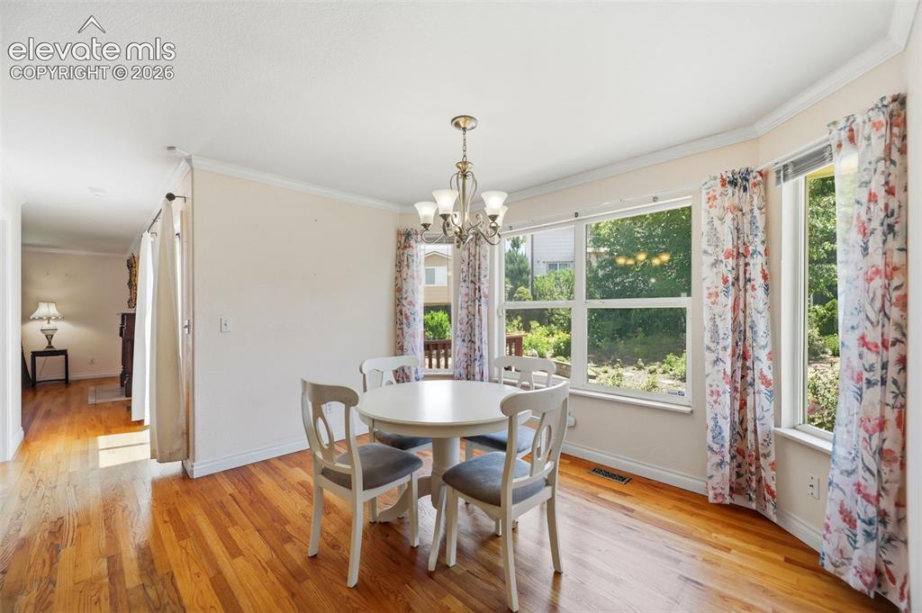 Image 10 of 50: Dining area featuring wood-finish flooring, a multi-pane window configurati