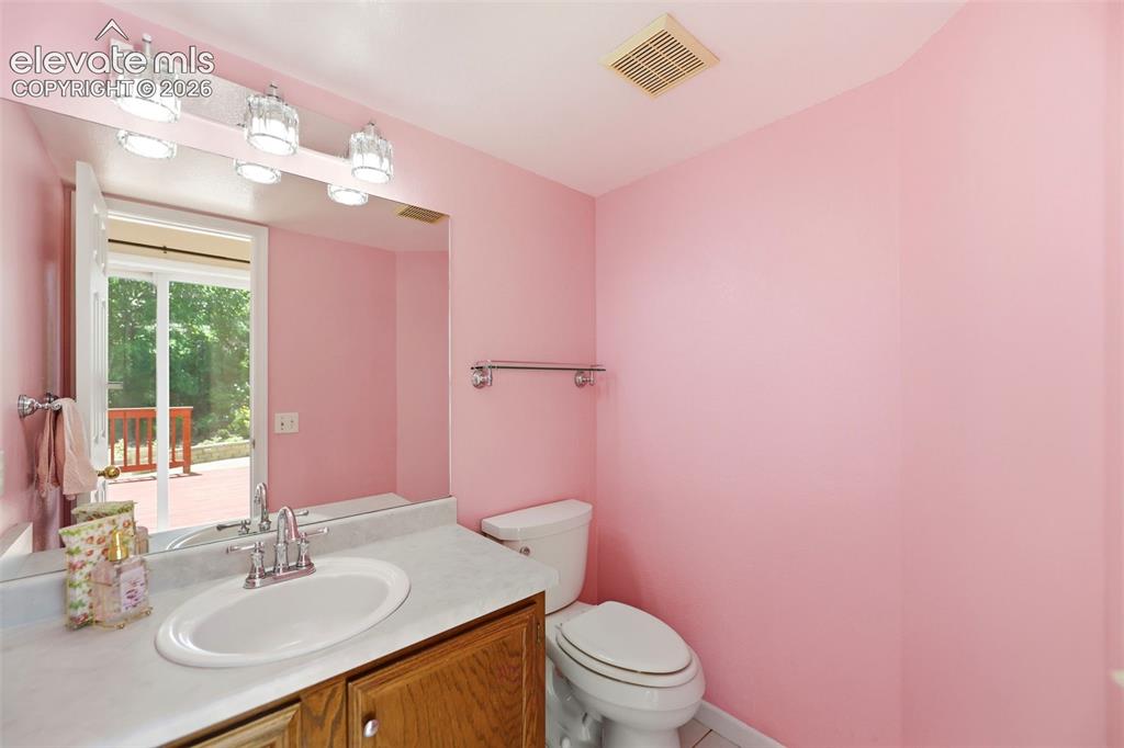 Image 11 of 50: Bathroom featuring a wood-finish vanity with a white countertop and integra