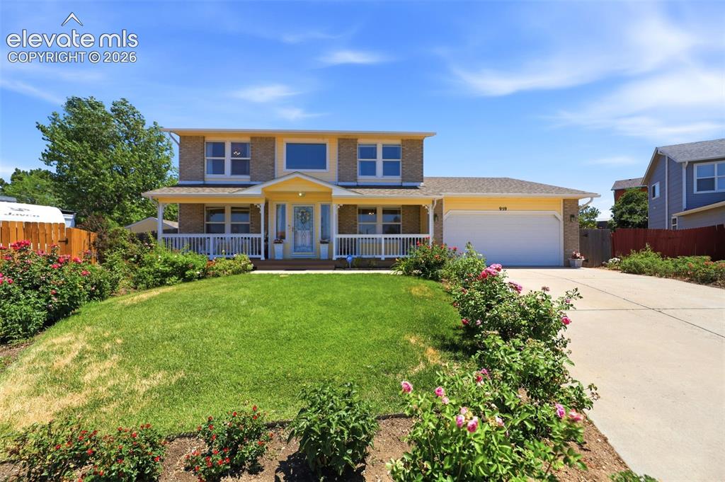 Image 2 of 50: Two-story residence featuring a covered front porch with white railings, a