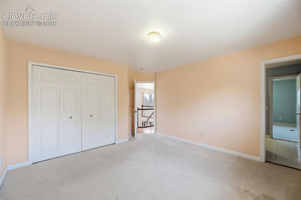 Image 25 of 50: Spacious room featuring neutral carpeting, a large bi-fold door closet, and