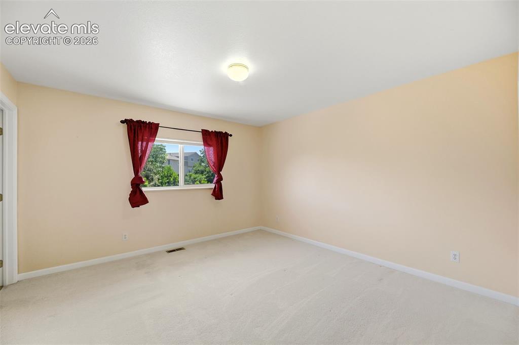Image 26 of 50: Bright interior space featuring light-toned carpeting and walls