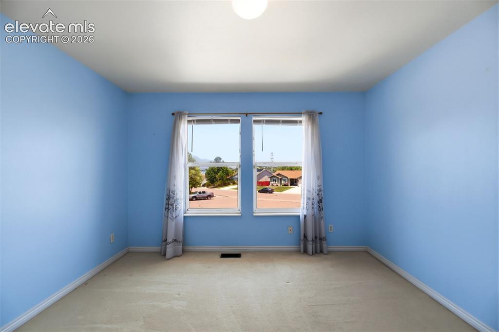 Image 27 of 50: Room featuring two windows with white frames, light blue painted walls, and