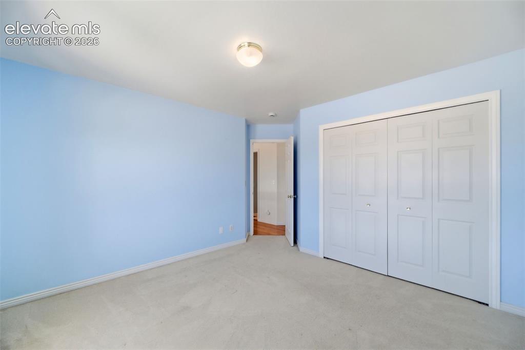 Image 28 of 50: Carpeted room with light blue walls and white trim