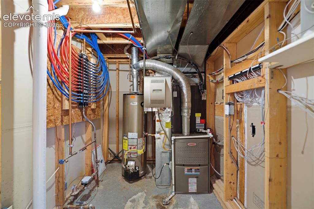 Image 34 of 50: Utility room featuring a water heater, furnace, and comprehensive plumbing