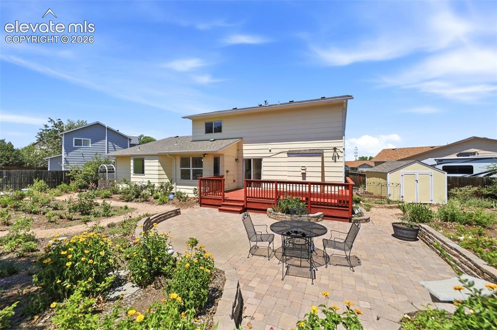 Image 38 of 50: Expansive outdoor living space featuring a paver patio and a multi-level wo