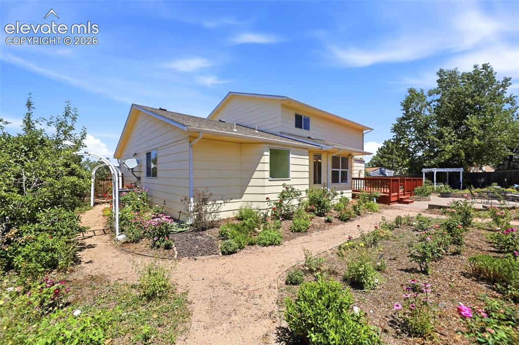 Image 39 of 50: Exterior siding in a light hue, featuring a multi-level deck with red raili