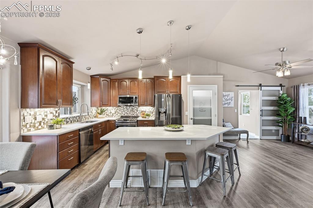 Image 10 of 50: Another view of the kitchen with the living room and entry to the right. Th