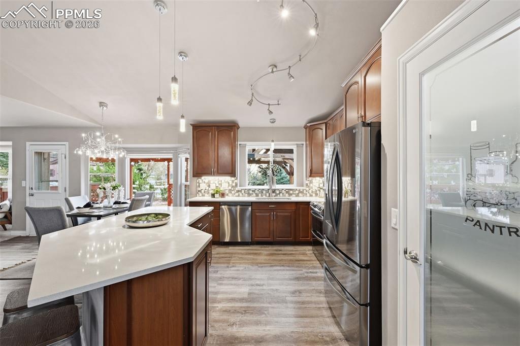 Image 14 of 50: Another view of the kitchen. Plenty of natural light in addition to the cei