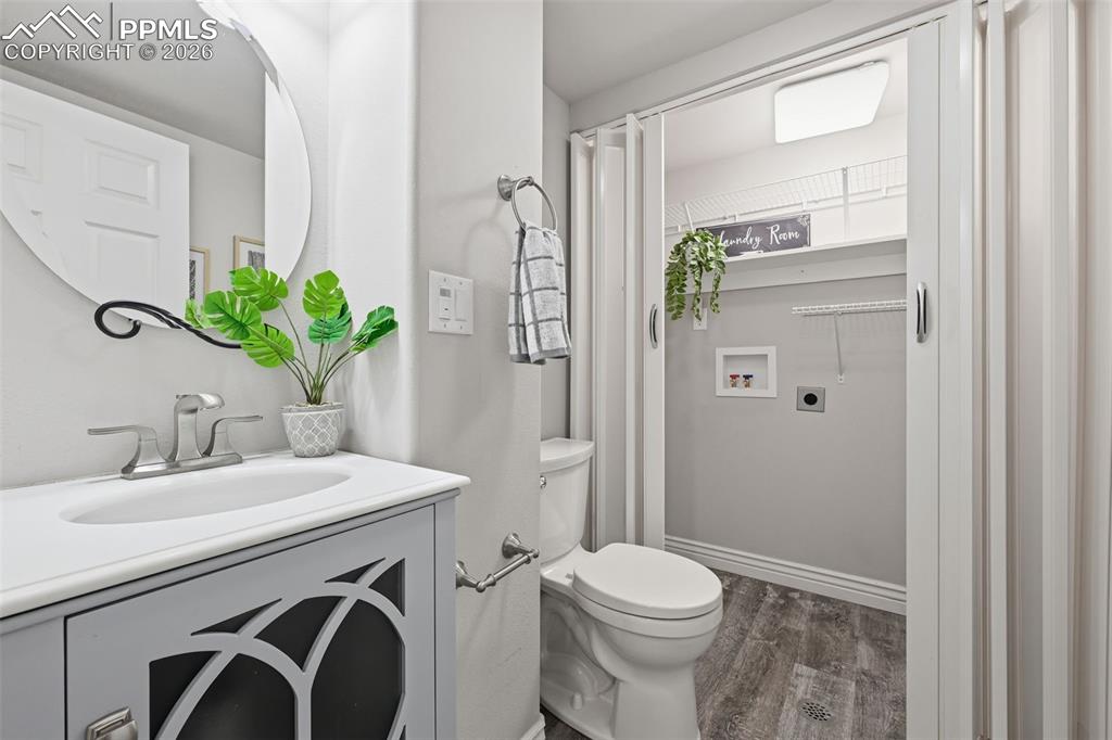 Image 20 of 50: The half bath on the main level for guests. A room with laundry hookups are