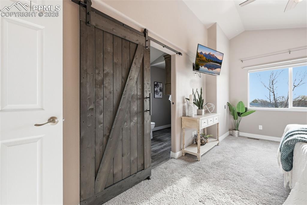 Image 23 of 50: The entrance to the ensuite bathroom. A barn door entrance adds to the appe