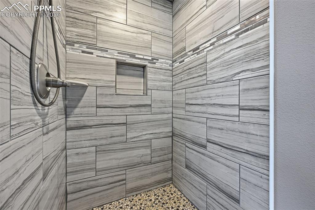 Image 25 of 50: The oversized free standing shower in the primary bathroom with custom tile