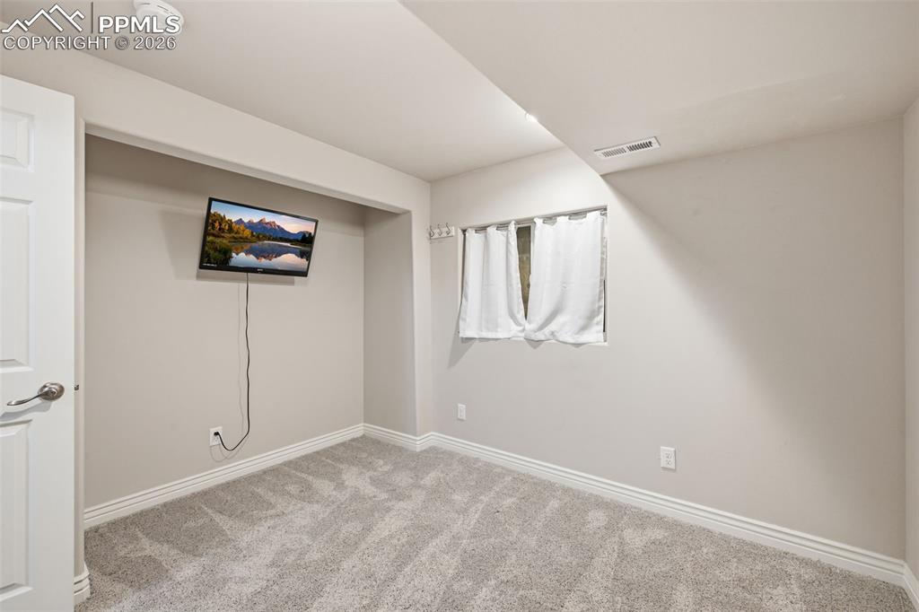 Image 34 of 50: This room in the basement can be used for an office or hobby room. Maybe ev