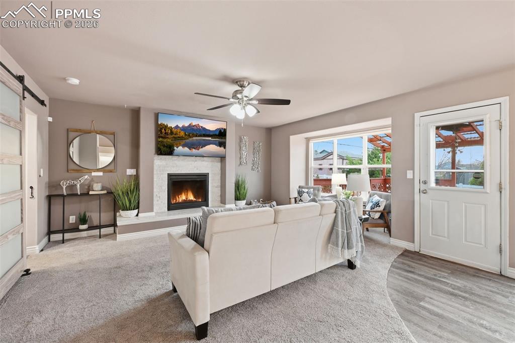 Image 5 of 50: The open family room with a gas burning fireplace with the entrance to the