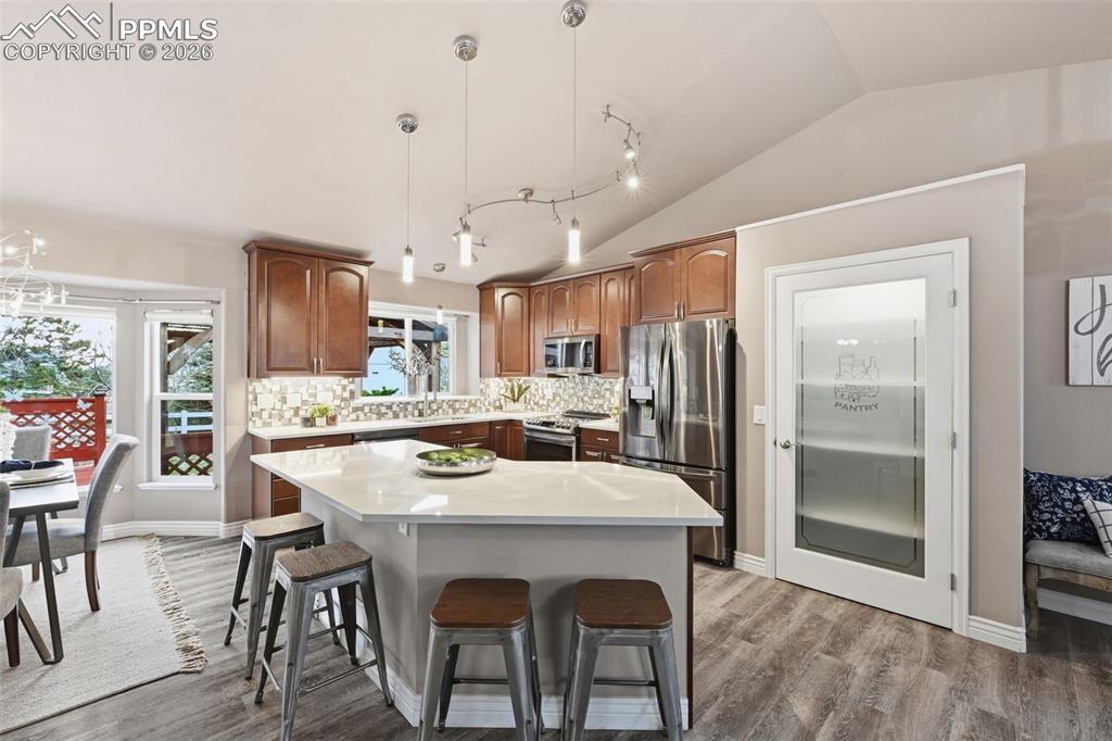 Image 9 of 50: A large kitchen island, a pantry and beautiful quartz, no maintenance count