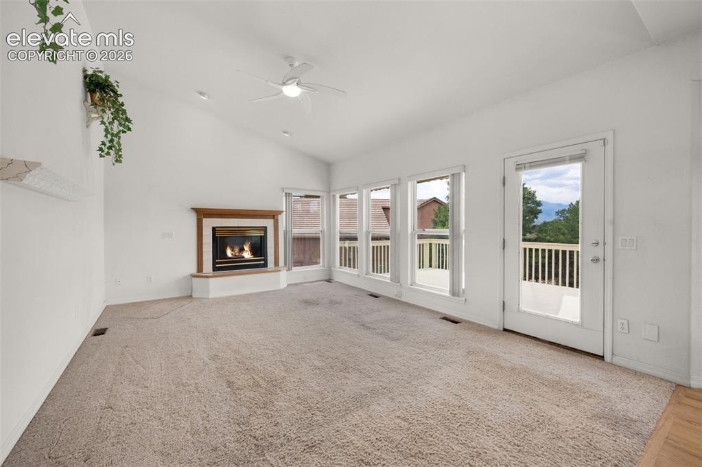 Image 16 of 48: Family Room Featuring Gas Log Fireplace, Vaulted Ceilings, Walk-out to Deck