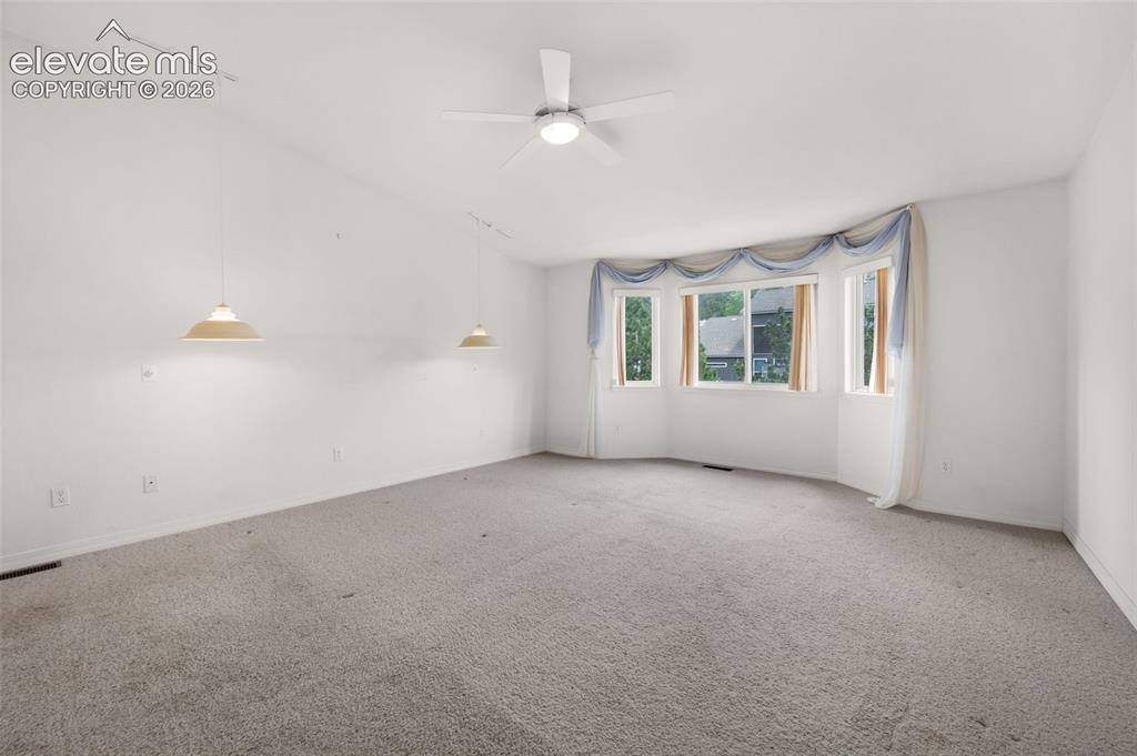 Image 23 of 48: Primary Bedroom Featuring Bay Window, Vaulted Ceilings and Ceiling Fan