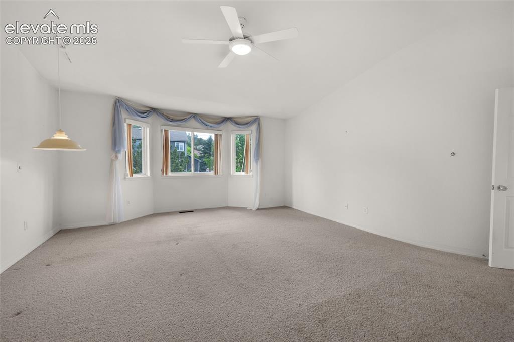 Image 26 of 48: Primary Bedroom Featuring Bay Window, Vaulted Ceilings and Ceiling Fan