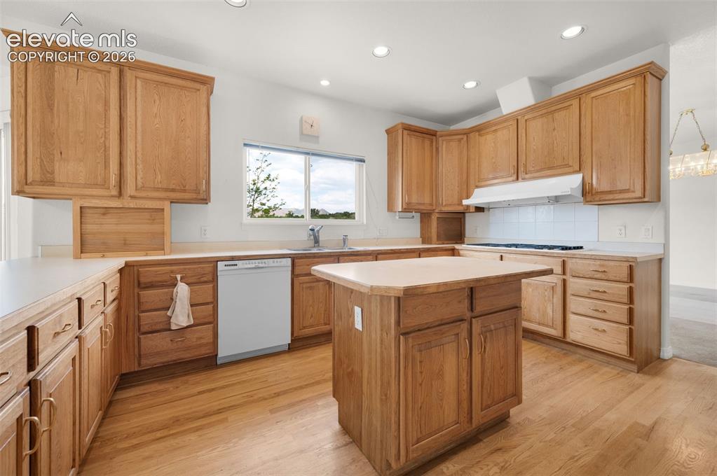 Image 3 of 48: Kitchen Featuring Island, Counter Bar and Hickory Wood Cabinets