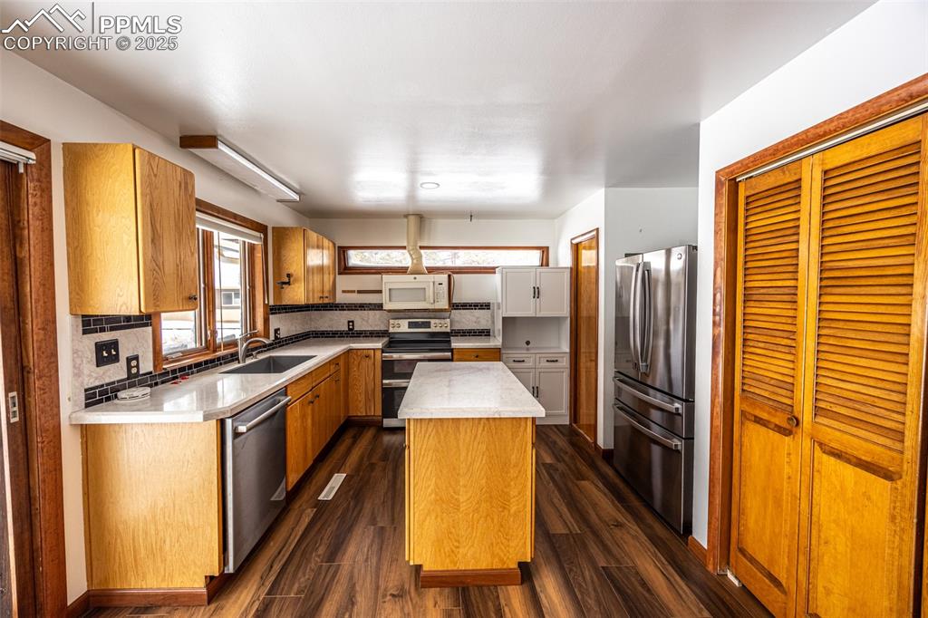 Image 12 of 36: Kitchen featuring a sink, tasteful backsplash, a kitchen island, appliances