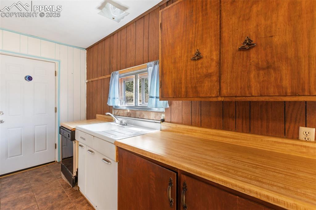 Image 13 of 41: Walk-out to the covered back deck. Deep farm sink and plenty of countertop 