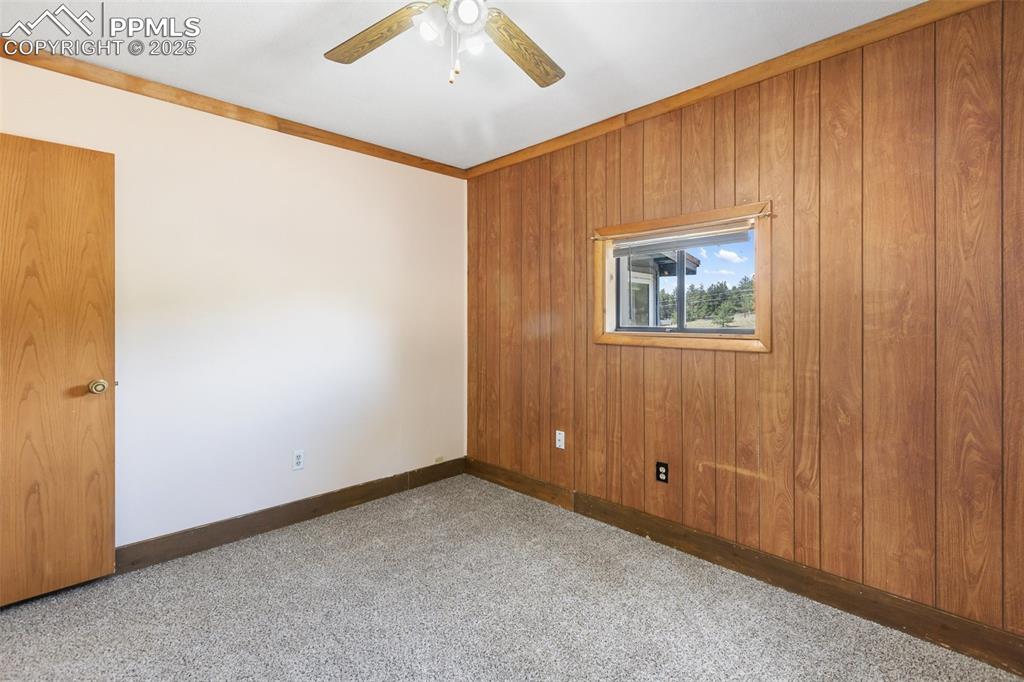 Image 19 of 41: Bedroom with mountain views. Ceiling fan and carpeted floors. 
