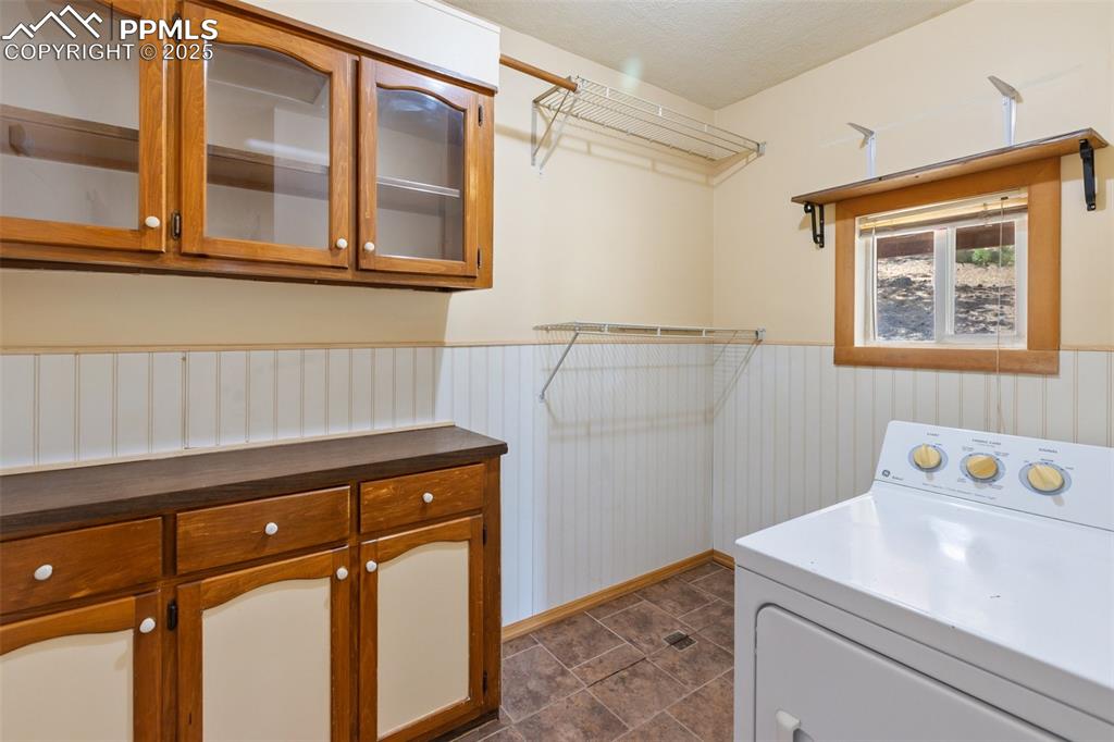 Image 21 of 41: Large laundry room with storage cabinets and folding surface. Use as a pant