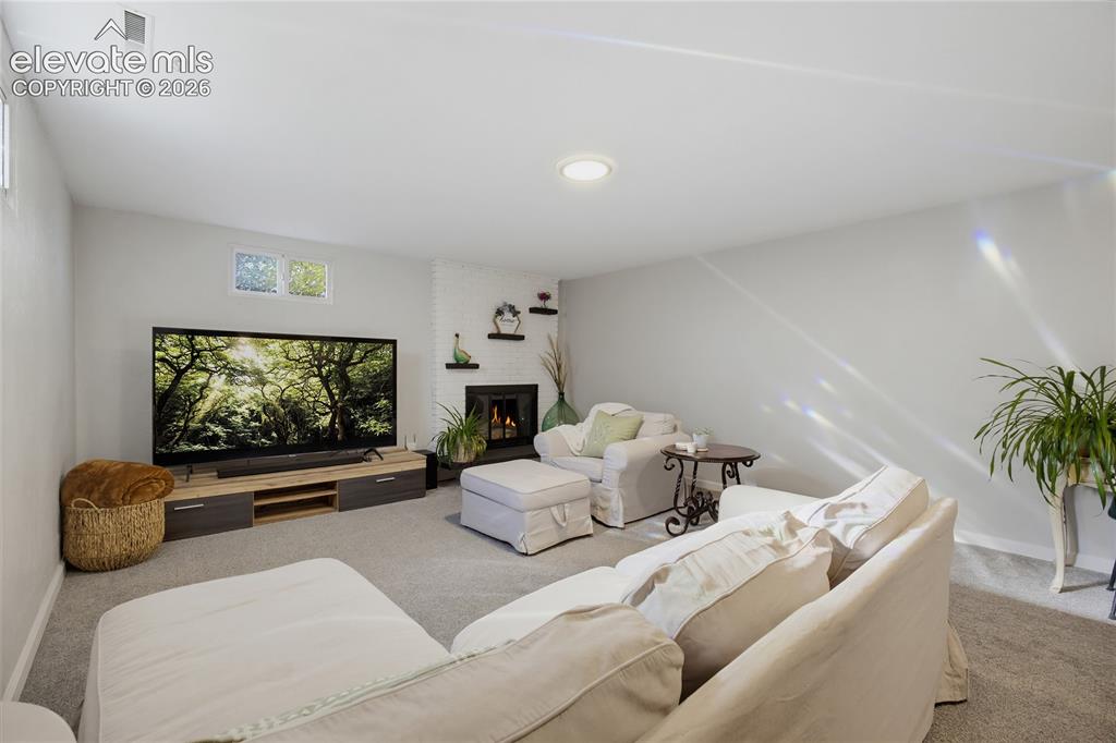 Image 22 of 29: Recessed lighting, light gray carpeting, built-in fireplace, and a wood-fin