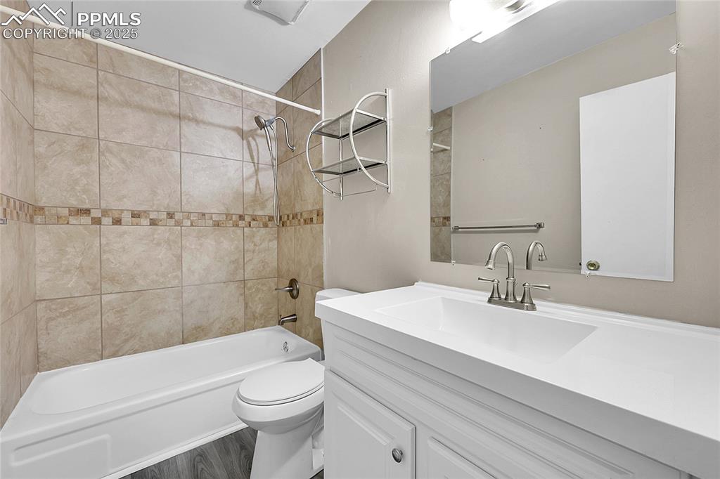 Image 30 of 33: Bathroom with vanity, tub / shower combination, and wood finished floors