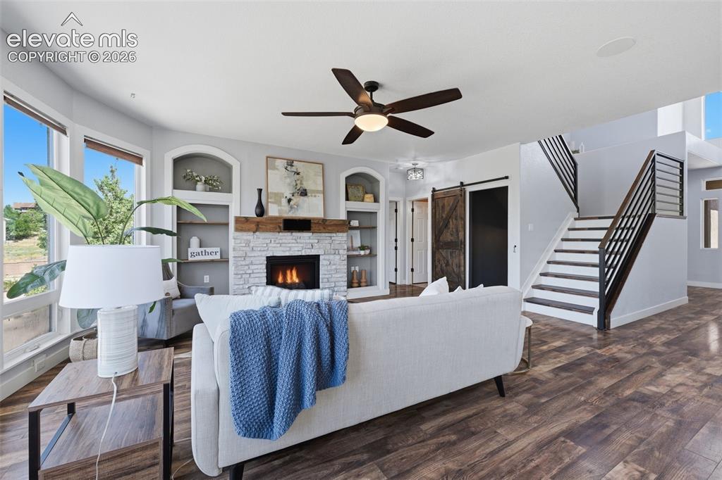 Image 14 of 49: Stone fireplace, barn doors, horizontal rails and painted stair risers!