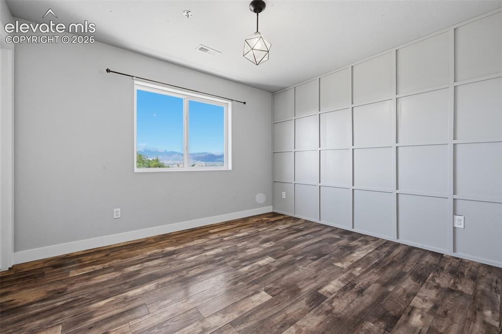 Image 36 of 49: Another focus wall and more plank flooring in bedroom 4!  