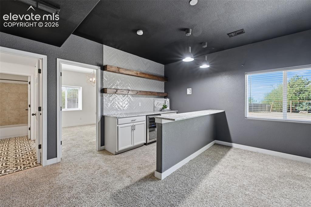 Image 39 of 49: Walk out basement with wonderful wet bar and wincooler!