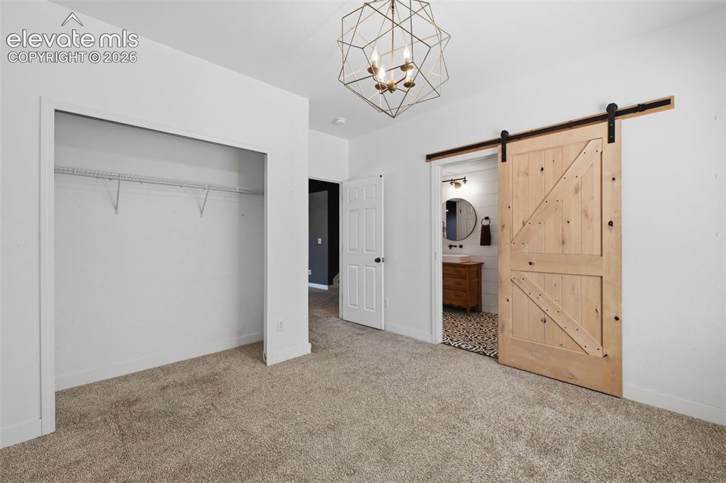 Image 43 of 49: Bedroom #5 in the basement with barn door to the jack-n-jill bath!