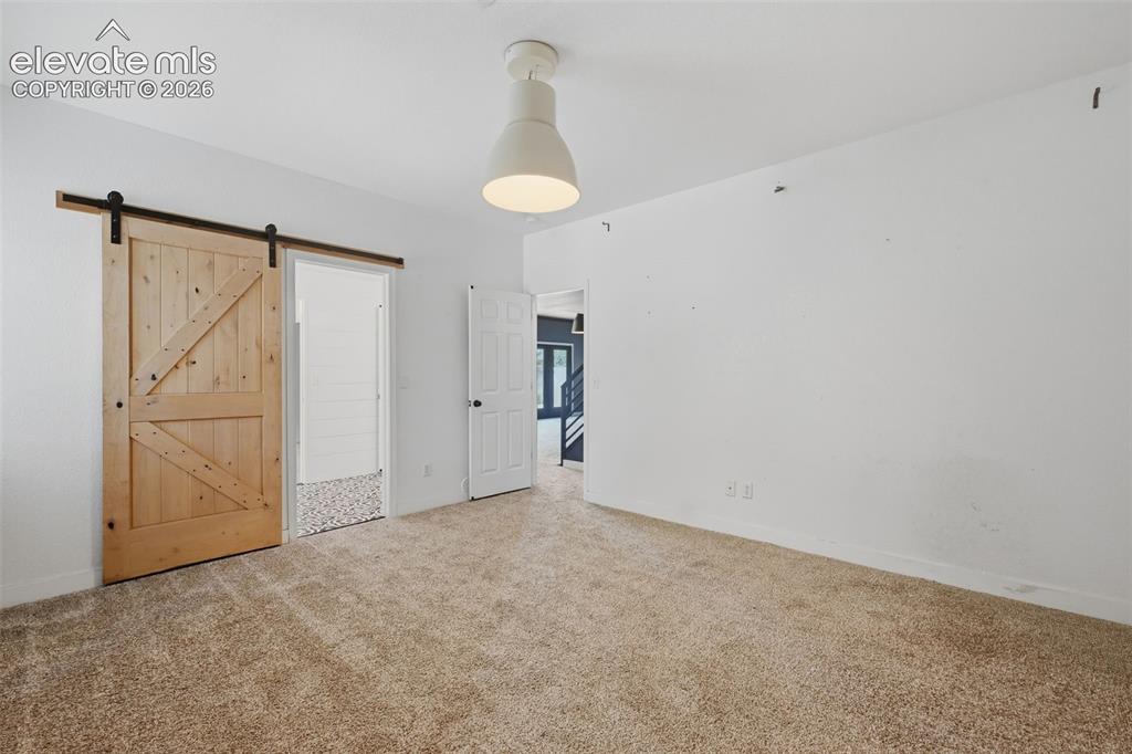 Image 45 of 49: Bedroom #6 with barn door to the jack-n-jill bath and walk in closet!
