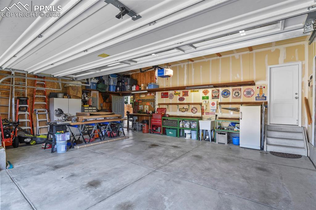 Image 36 of 43: 3-Car Garage with utility sink & door to backyard