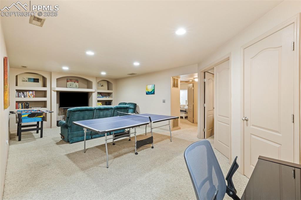 Image 17 of 27: Recreation room featuring recessed lighting, light carpet, and built in fea